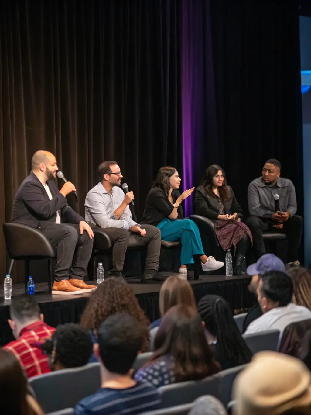 A dynamic image of a conference session at EMPRISE MARSEILLE, featuring a panel of artists discussing contemporary art trends and challenges.